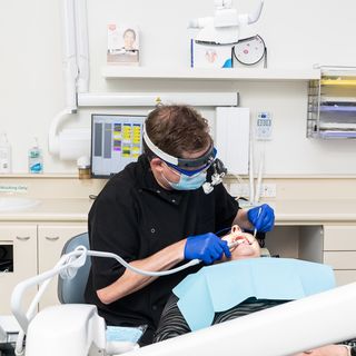Image of a dentist performing surgery on their patient.