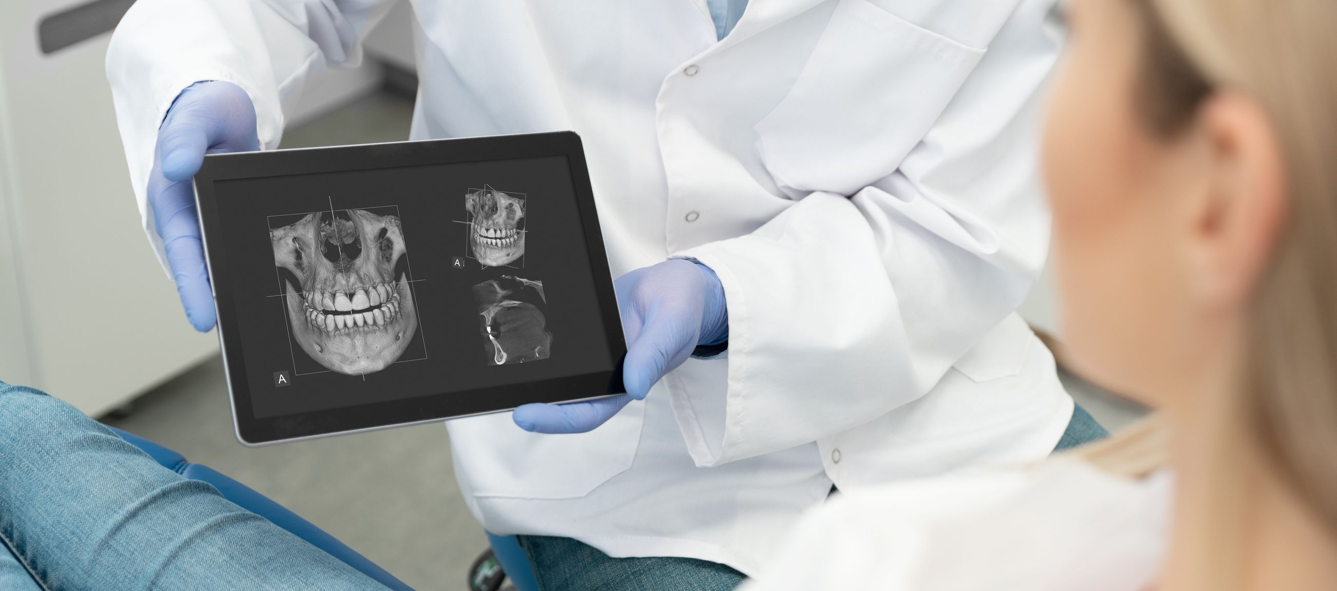 Image of a dentist holding a tablet with x-ray scans.