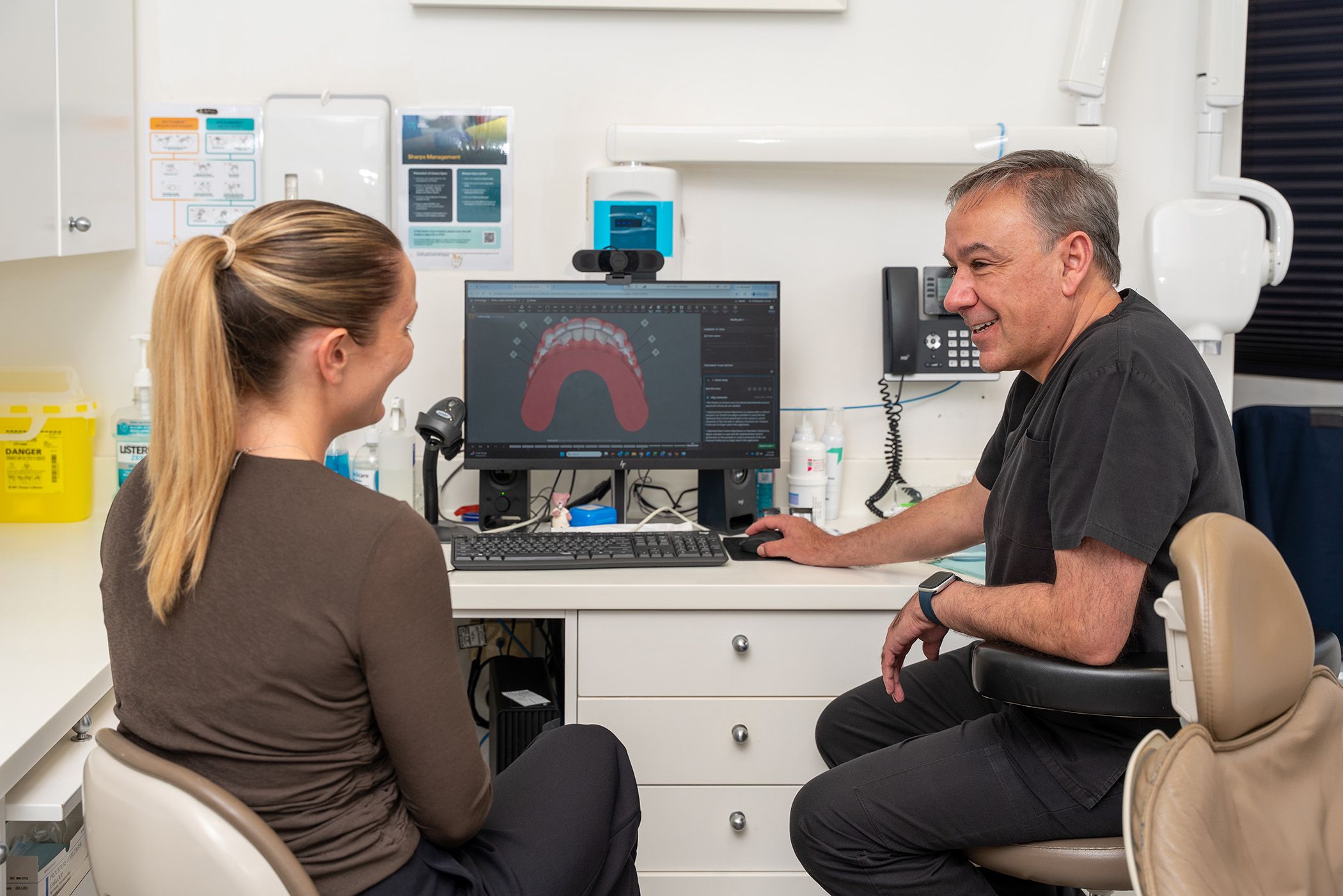 Image of our dentist, Dr Sam Guirguis smiling with his patient.