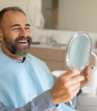 Smiling dental patient looking in the mirror