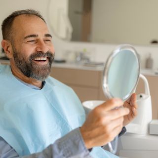 Image of a man looking at his teeth with happiness.