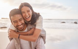 Happy couple smiling on the beach