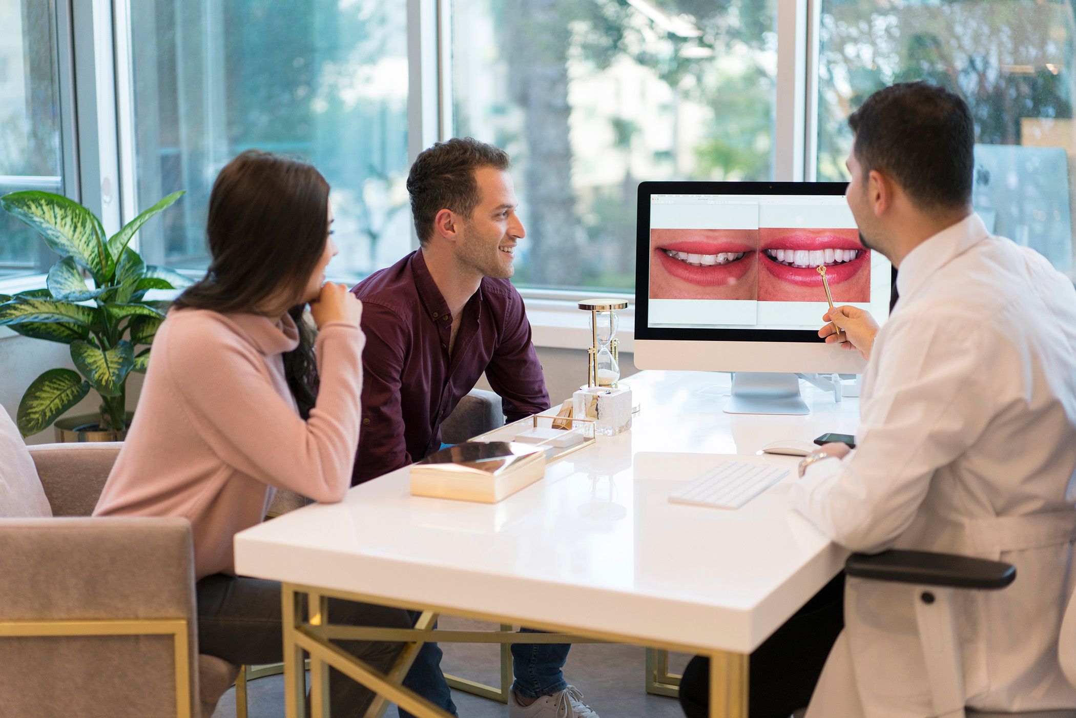 Image of a dentist showing their smile on a computer.