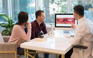 Image of a dentist showing their smile on a computer.