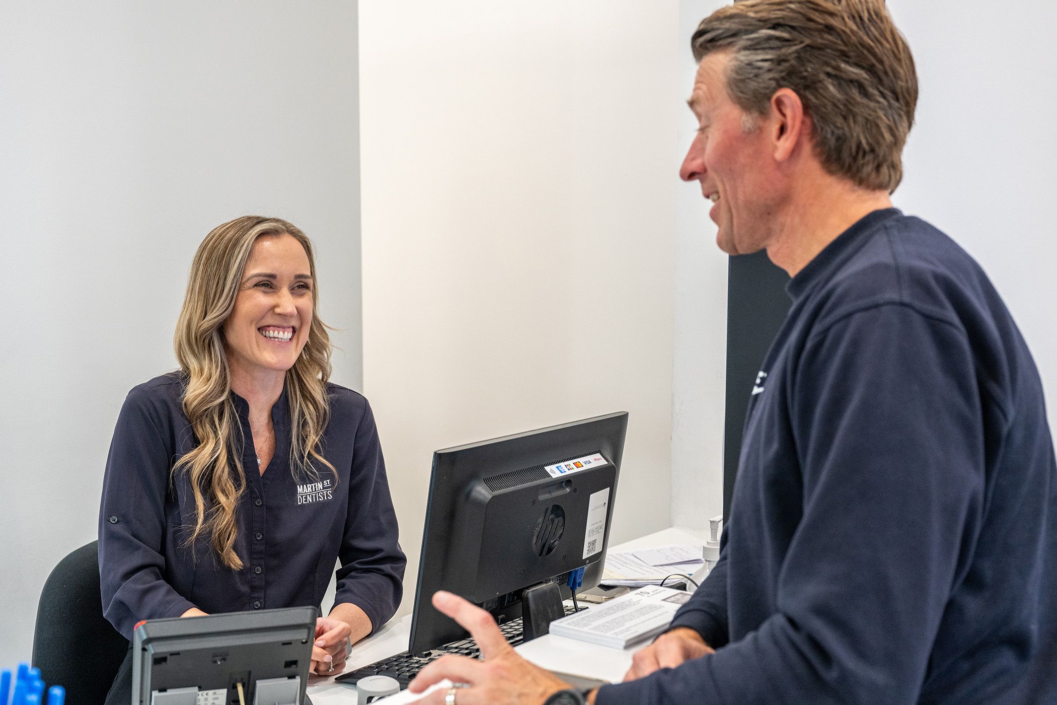 Our receptionist welcoming our young patient's parent into our dental clinic.