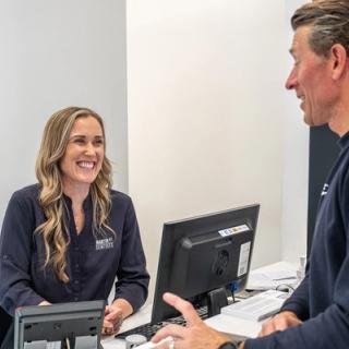 Our receptionist welcoming our young patient's parent into our dental clinic.