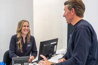 Image of our Martin Street reception with a happy patient, both are having a conversation.