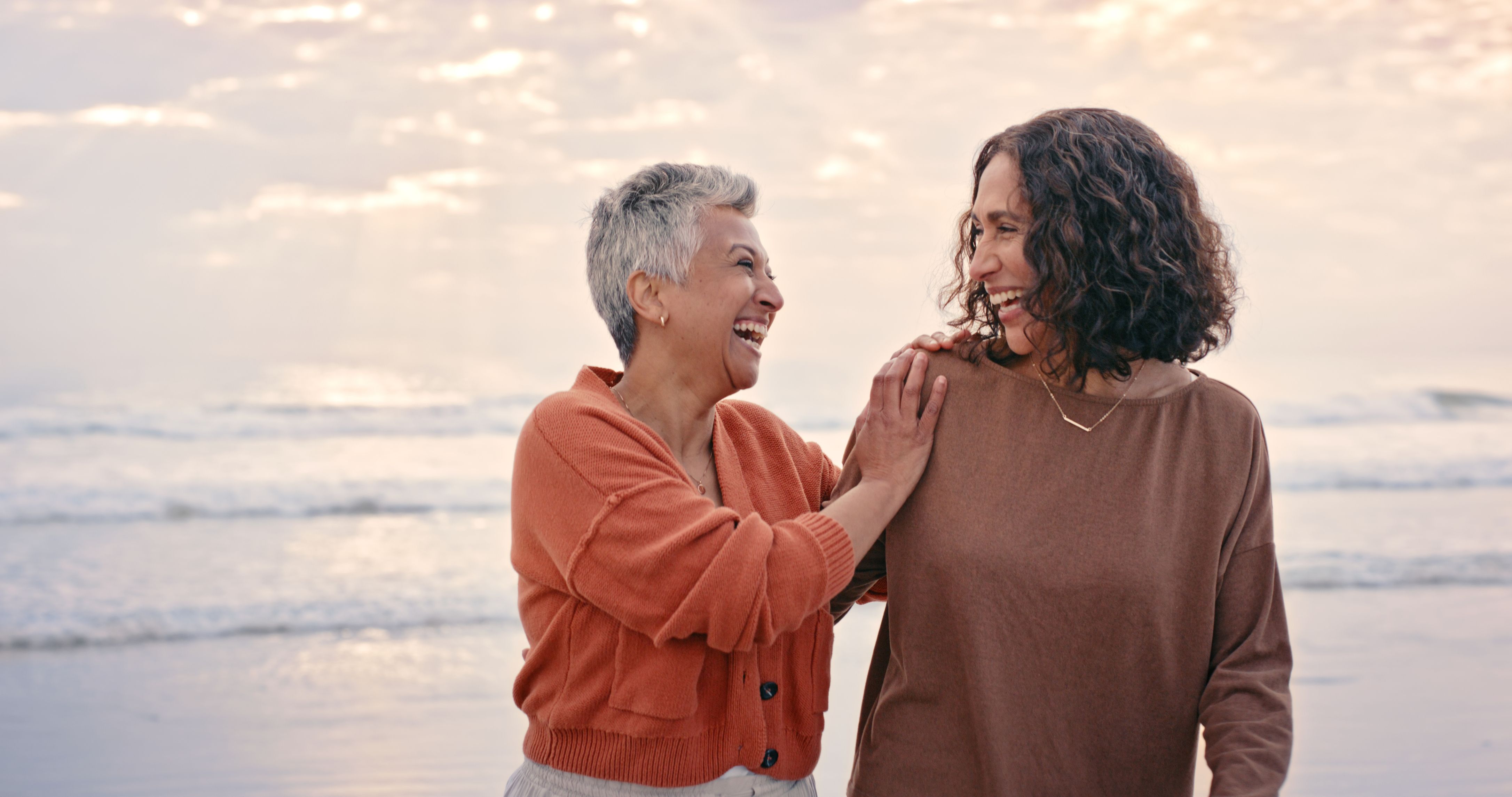 Image of a mother and her daughter on a beach together during an overcast day.