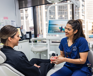 A patient with her dentist discussing possible treatments that will benefit her oral health.