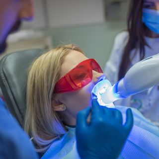 Image of a patient undergoing a in-chair teeth whitening procedure.