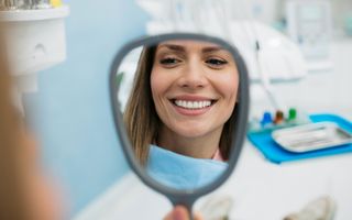 Image of female enjoying her white teeth after her cosmetic procedure.