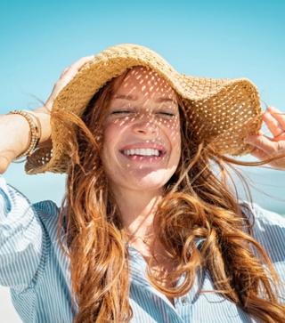 Image of female in the sun enjoying her white teeth.