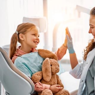 A dentist bonding with her young patient to create a comfortable and relaxing atmosphere.