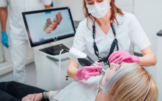 Dentist scanning a patients mouth using CEREC technology