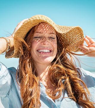 Image of a lady in the sun with a big white smile on her face.