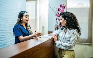 Patient talking with receptionist about payment plans
