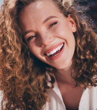 Image of a lady enjoying her white teeth.