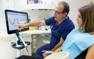 Image of Dr Chris Karikios going through an Invisalign scan with a dental patient.