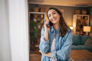 Image of a female at her home making a call on her cellphone.