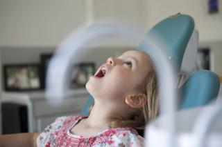 Image of a child at the dentist enjoying her time.