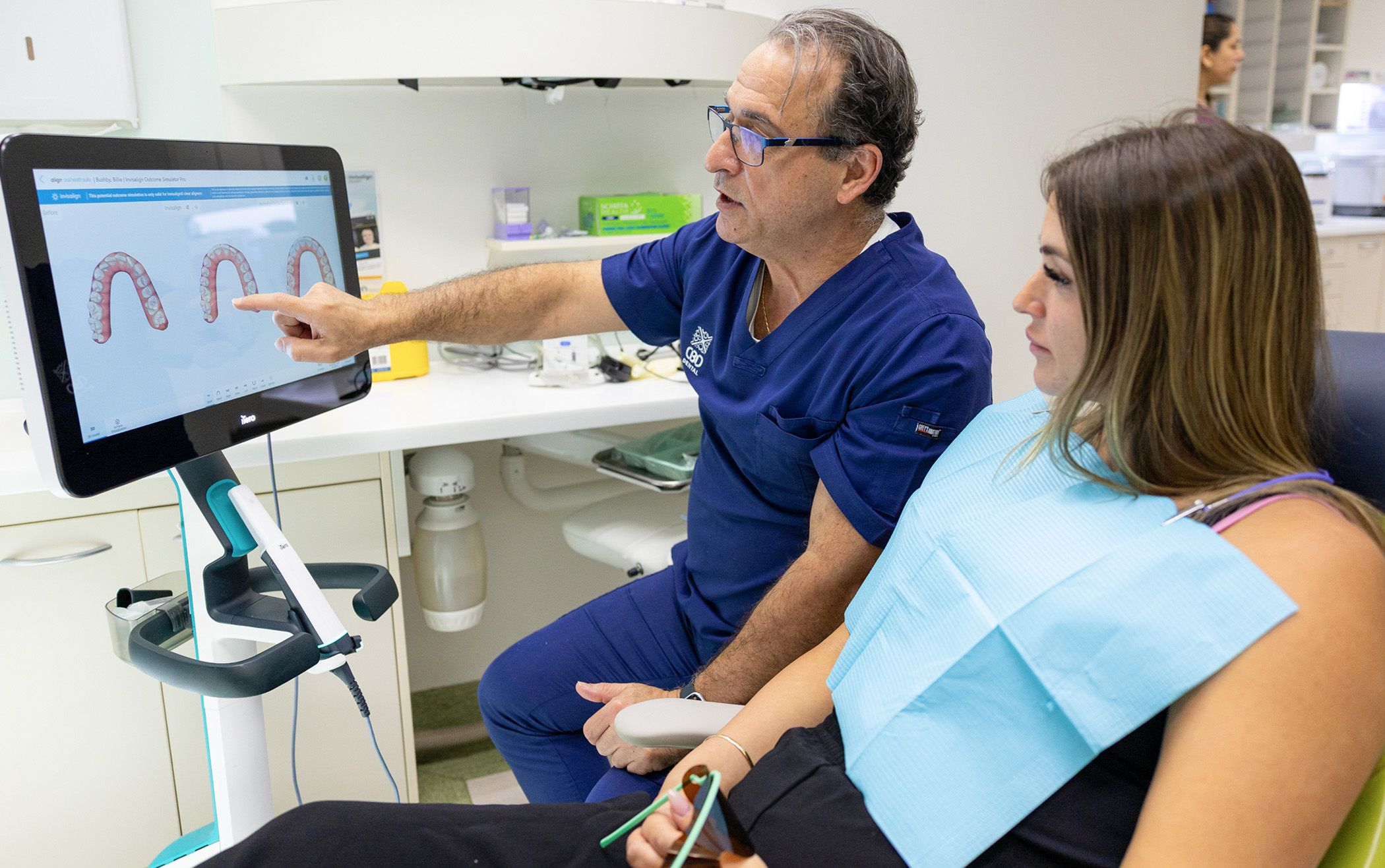 Image of Dr Chris Karikios showing a dental patient their smile preview in our clinic in CBD Sydney.