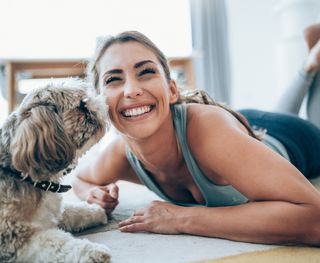 A female at home with her dog happy after her Smile Makeover here at KR Dental at Kippa-Ring.