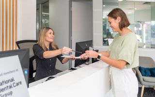 Image of our receptionist at DentArana helping out a patient.
