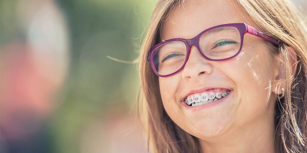 A child with orthodontic braces enjoying the sunny day.