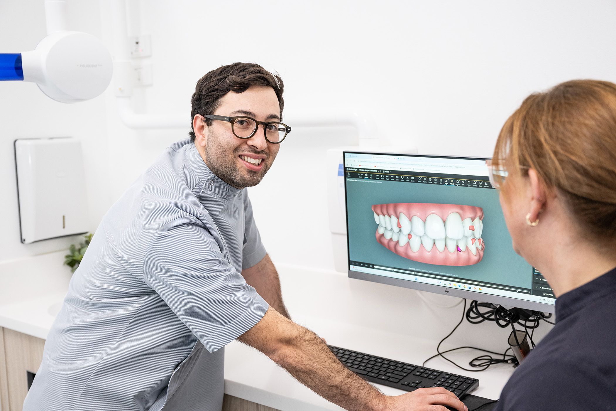 Image of Dr. Adam Sibio with a patient, discussing Invisalign treatment.