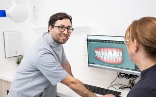 Image of Dr. Adam Sibio with a patient, discussing Invisalign treatment.