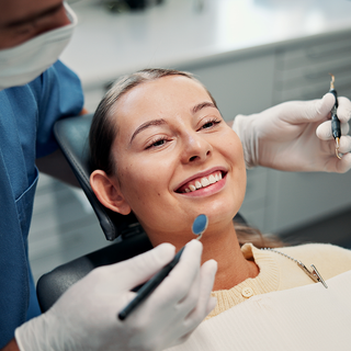 Image of a patient in a dental chair receiving treatment from a dentist.