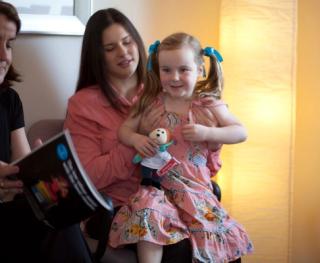 Child with her parent, brushing their teeth.