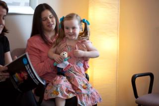 A child and their parent brushing their teeth.