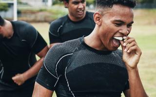 Image of a young boy putting on his custom-fitted mouthguard.