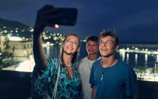 A group of friends at night with a bright new smile wearing Invisalign.