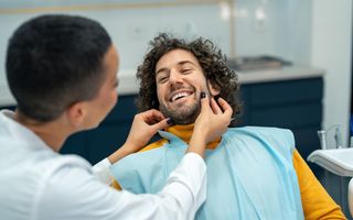 Image of dental patient with his dentist checking his teeth.