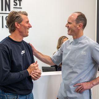 Image of Dr. Tim Nicolls having a discussion with one of his patient in the reception area of the dental practice.