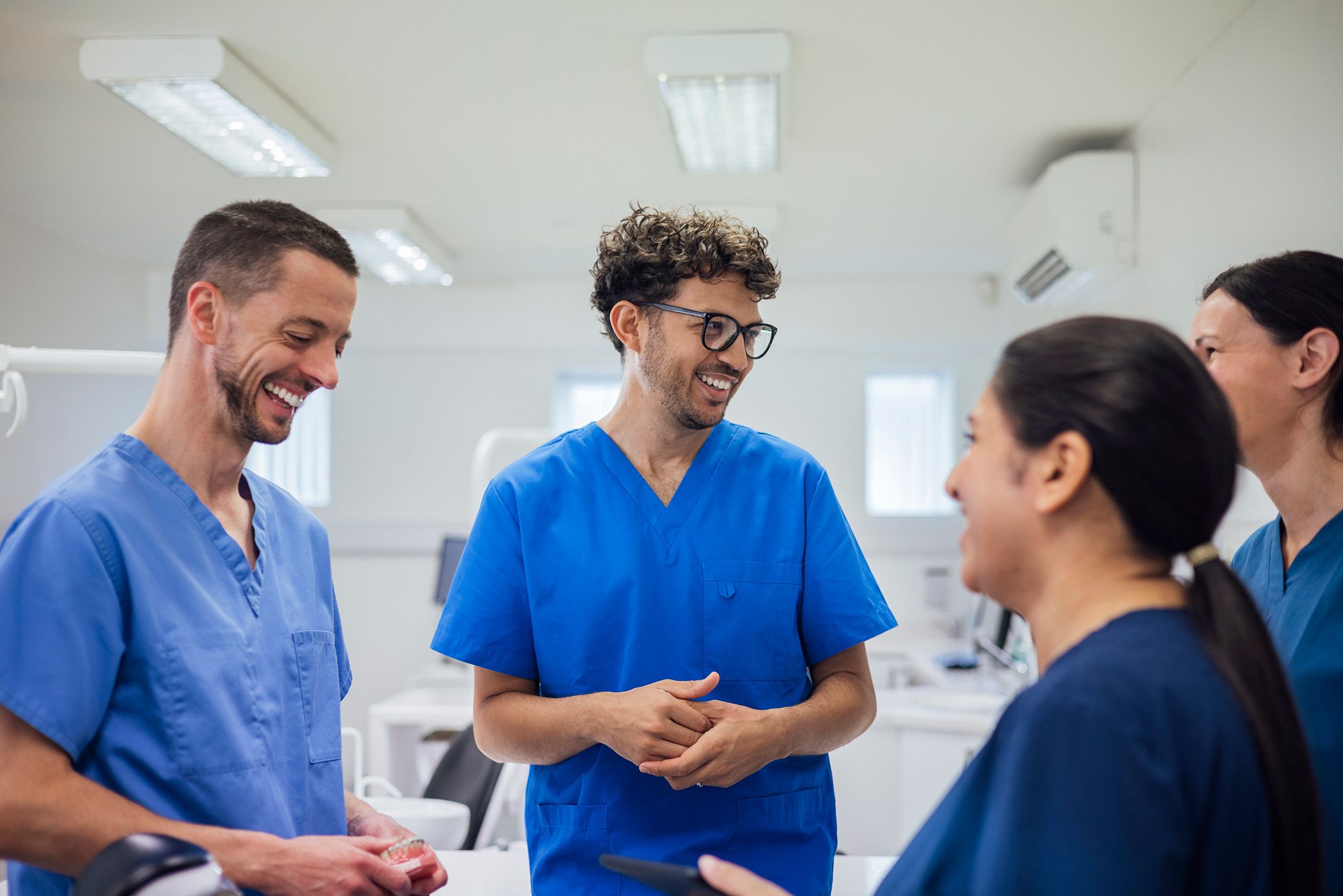 Image of a group of dentists and dental assistants socialing at a clinic.