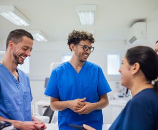 Image of a group of dentists and dental assistants socialing at a clinic.