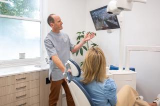 Image of Dr. Nicolls with his patient discussing a dental treatment.