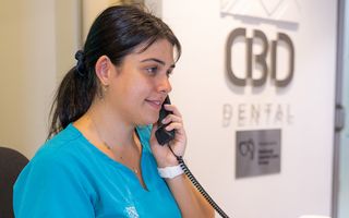 Image of our receptionist at CBD Sydney getting a patient ready for their dental appointment.