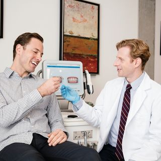 Image of a patient and a dentist in a dental practice discussing the correct treatment.