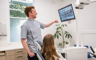 Image of Dr. Borger with a patient going through their dental results.