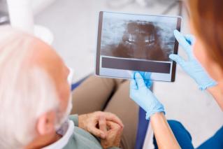 Patient in chair with dentist viewing their teeth scans