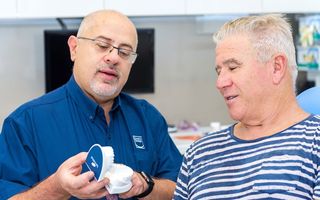Image of Dr. Remo Fanelli with a patient showing his mouthguards.
