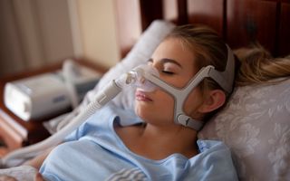 Sleeping female using a CPAP maching
