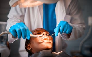 Image of a dentist checking his patient's teeth.