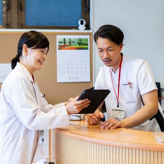 Image of a dentist with a receptionist talking clinical issues.