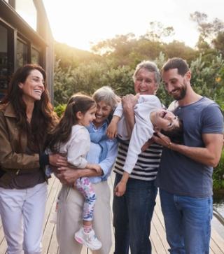 Image of a family hugging each other at their house.