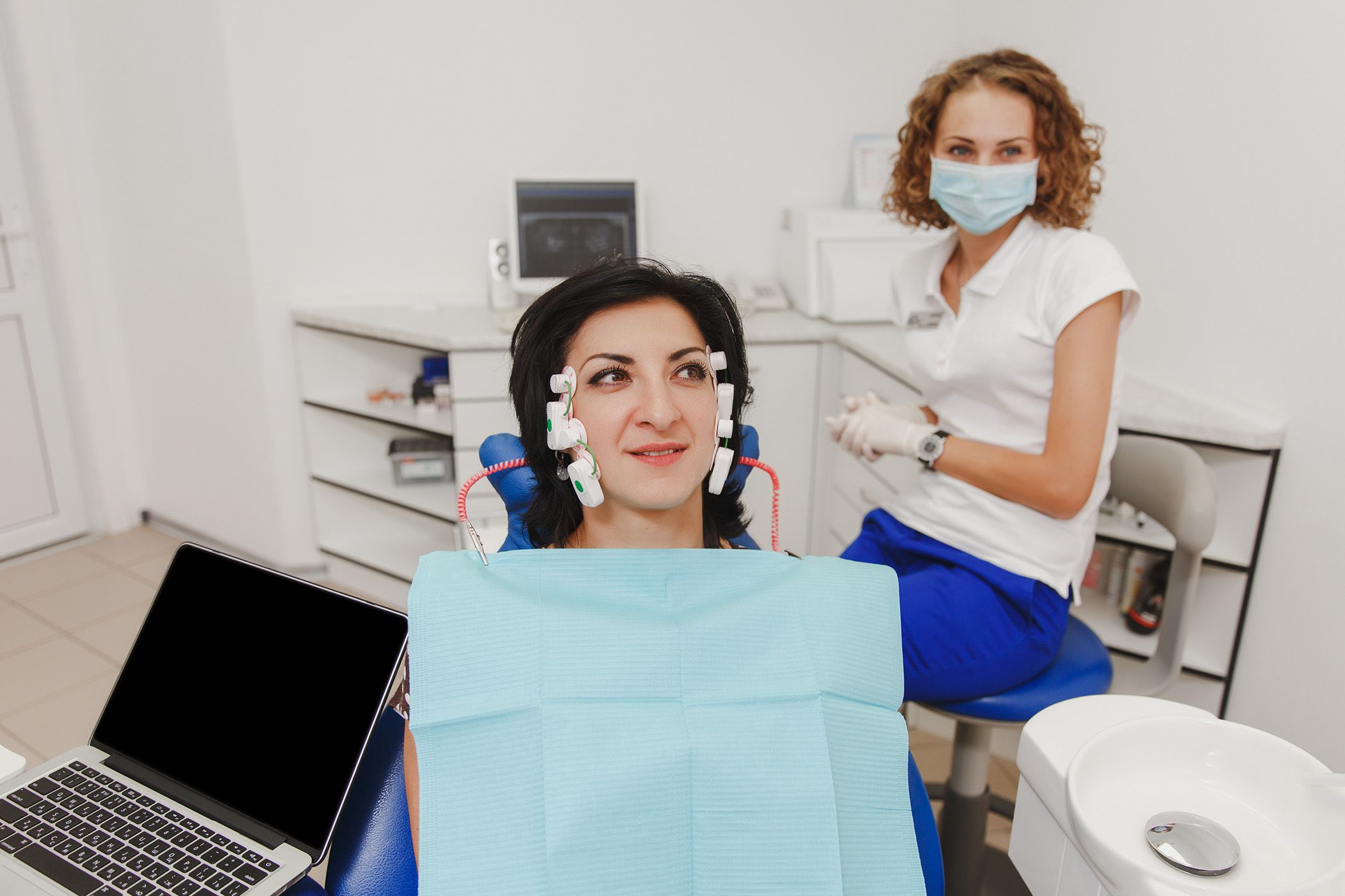 A patient undergoing TENS therapy with her dentist.